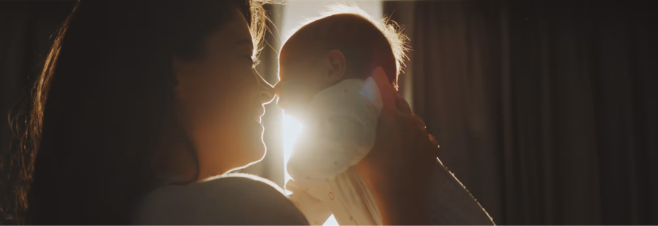 Mother holding baby in warm light